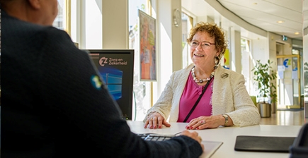 Een vrouw wordt geholpen aan de balie bij Zorg en Zekerheid